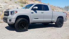 a white truck parked on top of a dirt field