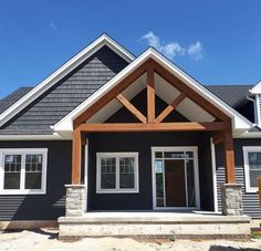 a gray house with white trim and wood accents