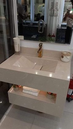 a bathroom sink sitting under a mirror next to a counter top with lights on it