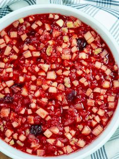 a white bowl filled with cranberry sauce on top of a blue and white checkered table cloth