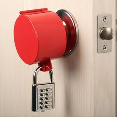 a red alarm clock mounted to the side of a door with a padlock on it