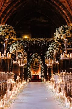 the aisle is lined with candles and flowers for an elegant wedding ceremony at night time