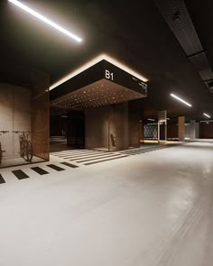 an empty parking garage with lights on the ceiling and white flooring in front of it