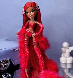 a barbie doll is standing in front of a car with red feathers on it's tail