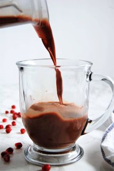 someone is pouring chocolate into a glass cup