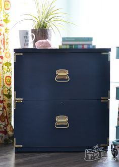 a blue dresser with two drawers and a potted plant on top