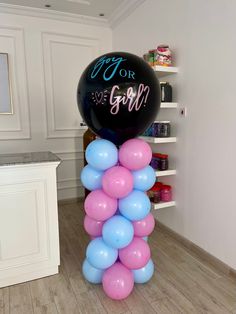 a bunch of balloons sitting on top of a wooden floor next to a white wall