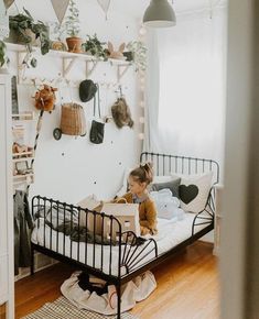 a toddler is sitting in his bed reading a book