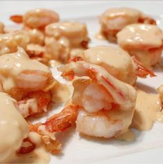 some shrimp with sauce on it sitting on a white plate