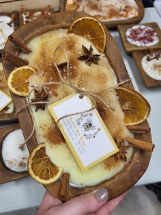 a person holding an orange slice with cinnamon on it