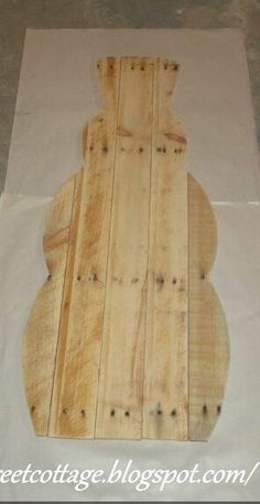 an unfinished wooden board sitting on top of a white piece of paper with holes in it