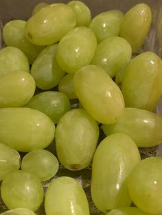 green grapes are sitting in a glass bowl