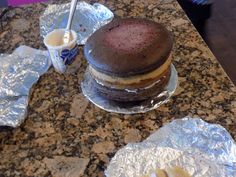 a chocolate dessert sitting on top of aluminum foil next to a cup of ice cream