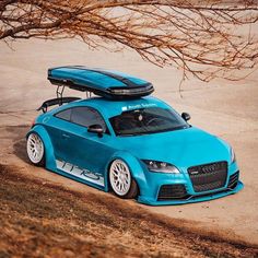 a blue sports car with a surfboard on top