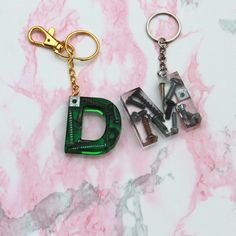 two key chains with the letters d and n on them sitting next to each other