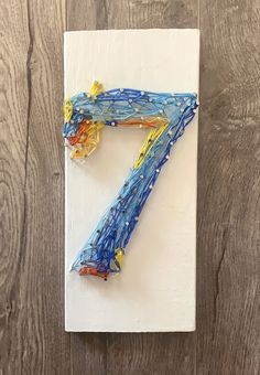 the number seven is made out of plastic wrappers on top of a piece of paper