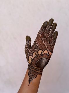 a woman's hand with henna tattoos on it