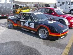 an old race car with numbers painted on it's side parked in a parking lot