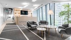 an office lobby with chairs and tables in front of large windows that look out onto the city