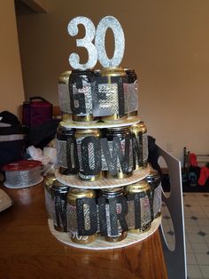 a cake made out of cans with the number 30 on it's top tier