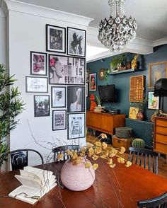 a dining room table with pictures on the wall