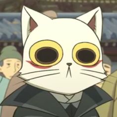 a white cat with yellow eyes standing in front of other people