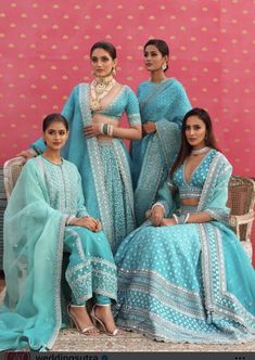 three women in blue dresses posing for the camera