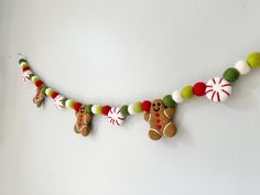 christmas decorations hanging on the wall with gingerbreads and candy canes