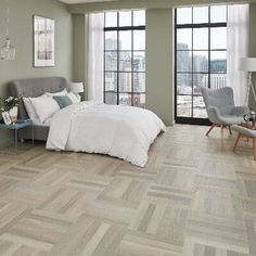 a bedroom with wood flooring and large windows overlooking the cityscape is pictured in this image