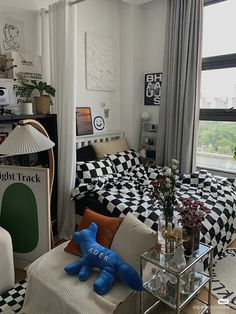 a bed room with a neatly made bed and a checkered comforter on the bed