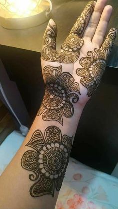 a woman's hand with henna tattoos on it