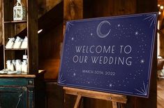 a welcome to our wedding sign on an easel in a room with wooden walls