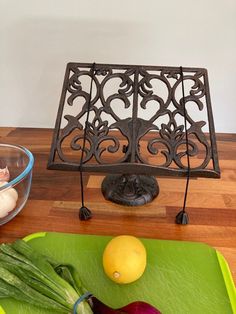 a cutting board with onions, lemons and other vegetables on it next to an iron grate