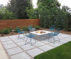 an outdoor fire pit surrounded by blue chairs