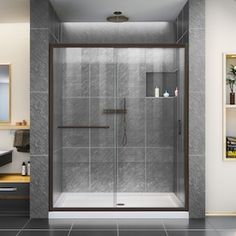 a bathroom with a walk in shower next to a sink and mirror on the wall