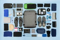 the contents of a backpack laid out on a blue surface with shoes and other items