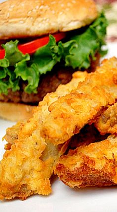 two fried chicken patties and a burger on a plate