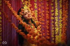 a woman standing in front of red and yellow flowers