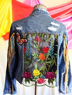 a jean jacket with flowers and butterflies on it