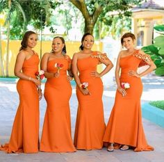 four beautiful women in orange dresses posing for the camera