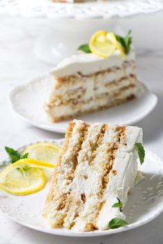 two slices of cake sitting on plates with lemons and mint garnishes