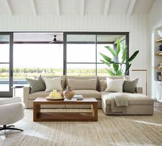 a living room filled with furniture and large windows