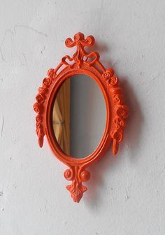 an orange mirror is hanging on the wall