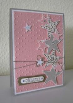 a pink card with silver stars on it