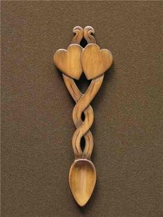 a wooden spoon with two hearts carved into it's sides, on a brown surface