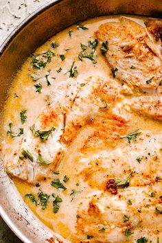 a pan filled with chicken and sauce on top of a table