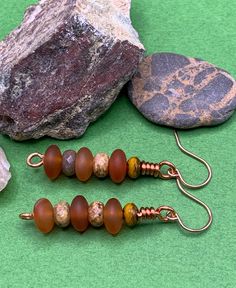 Carnelian and fossil jasper gemstones and a small mustard spacer bead with copper ear wires.  Carnelian has a nice deep orange red color, and the jasper really sets off the color of the carnelian beads.  These have a nice warm color tone, easing into the fall season.  A smashing pair for all the redheads out there. Brown Adjustable Earrings With Natural Stones, Artisan Brown Earrings With Natural Stones, Amber Natural Stones Earrings For Jewelry Making, Brown Earrings With Natural Stones And Round Beads, Earthy Brown Czech Glass Jewelry, Earthy Rust-colored Earrings For Gift, Earthy Rust-colored Earrings As Gift, Bead Dangles, Gem Earrings