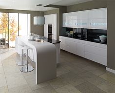 a modern kitchen with white cabinets and black counter tops, along with an island in the middle