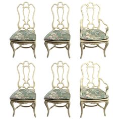 six white chairs with floral upholstered seats