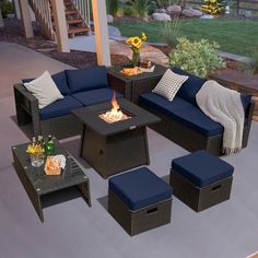 an outdoor living room with blue furniture and fire pit in the center, on a patio